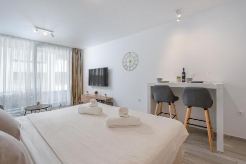 a white room with a bed and a table and chairs at Luni Apartment in Dubrovnik center in Dubrovnik