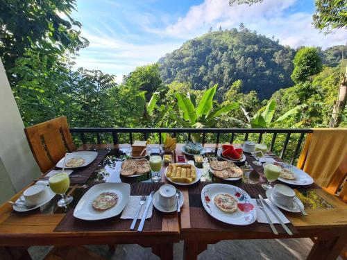 a wooden table with food on it with a view of a mountain at Ever Green Mount in Ella