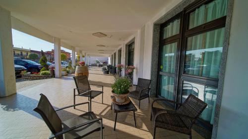 porche con sillas y mesa con maceta en Hotel Nuovo Sole HNS, en Bovolone