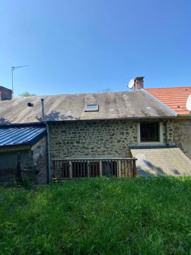 a stone house with a roof on top of a field at Petit cocon au cœur du Morvan in Montreuillon