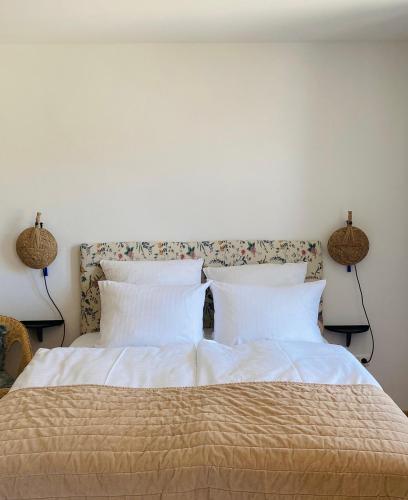 una camera da letto con un grande letto con lenzuola bianche e due lampade di Alte Mühle Maising a Pöcking