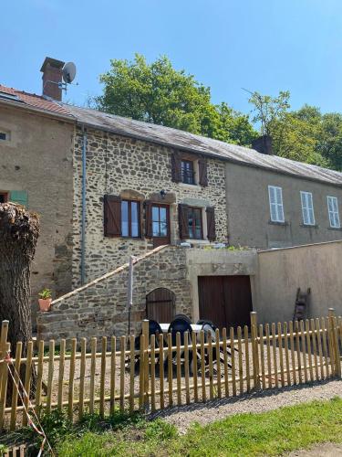 an old stone house with a wooden fence at Petit cocon au cœur du Morvan in Montreuillon