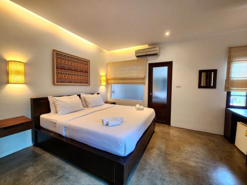 a bedroom with a large bed with white sheets at The Peaberry Boutique Hotel in Chiang Mai