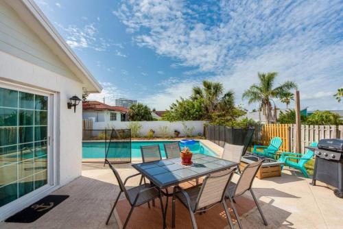 un patio con mesa y sillas y una piscina en Large pool home and blocks away from the beach, en Daytona Beach