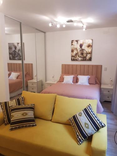 een woonkamer met een bank en een bed bij Godoy House in Buenos Aires