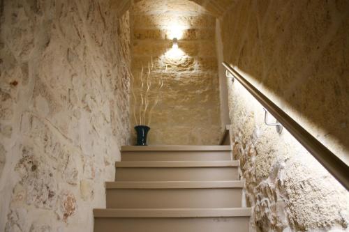 a staircase in a building with a stone wall at Muricis in Santeramo in Colle
