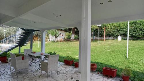 a patio with a table and chairs in a yard at Isidoros house in Néa Sílata