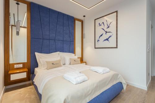 a bedroom with a large bed with a blue headboard at Villa Platinium in Opatija