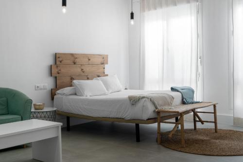 a bedroom with a bed with a wooden headboard at Apartamentos GAV in Ronda