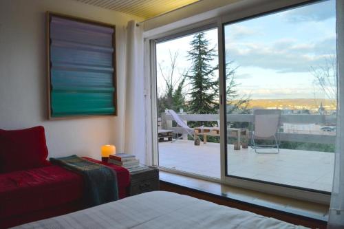 Schlafzimmer mit einem großen Fenster mit Blick auf einen Innenhof in der Unterkunft Casa mARTa : Suites, terrasses et vue panoramique in Tournon-sur-Rhône