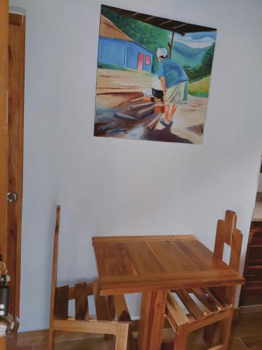 a table and chairs with a painting on the wall at Villas Montelindo in Constanza