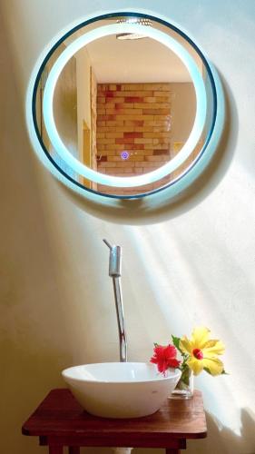 a bathroom sink with a mirror on a wall at Chalés Amarante in Fortim