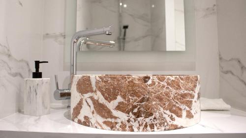 a bathroom with a marble sink with a faucet at les charmes de la vallée noble in Soultzmatt
