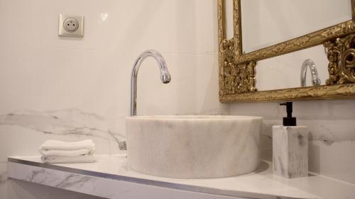 a white sink in a bathroom with a mirror at les charmes de la vallée noble in Soultzmatt