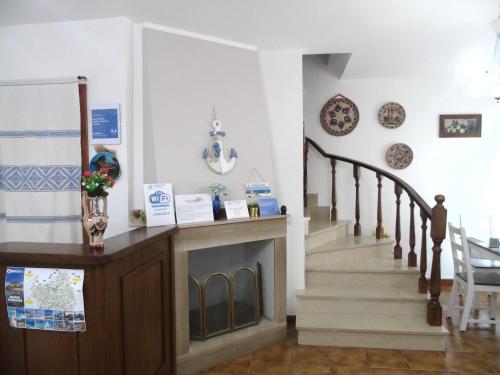 a living room with a fireplace and a staircase at Casa Vacanza LiHele - Locazione Turistica in Castelsardo