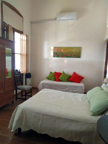 a bedroom with two beds with red and green pillows at La Soñada in La Paz