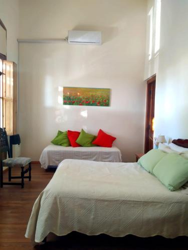 a bedroom with two beds and a painting on the wall at La Soñada in La Paz