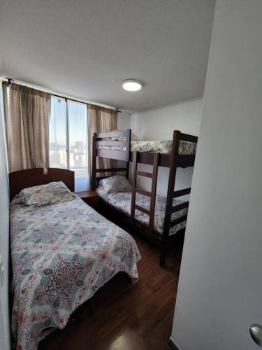 a bedroom with two bunk beds and a window at Familiar en el centro de Santiago 16 B in Santiago