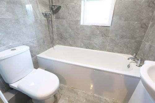 a bathroom with a toilet and a tub and a sink at House near city centre in Leicester