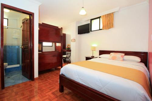 a bedroom with a large bed and a bathroom at La Rosario in Quito