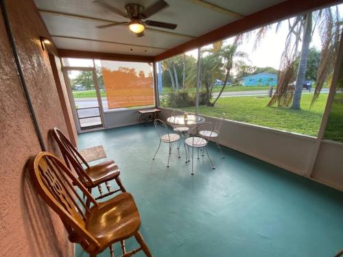 a screened in porch with a table and chairs at Vintage Vero Bungalo II in Vero Beach