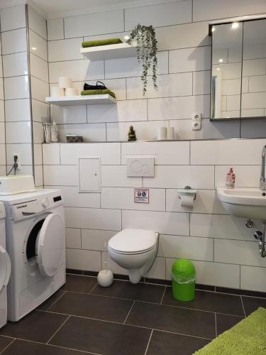 a white bathroom with a toilet and a sink at Ferienhaus Budenheim in Budenheim
