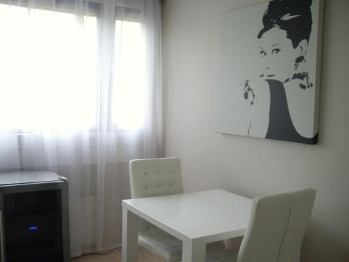 a white table and chair in a room with a window at 21 minutes from Helsinki city - smaller room in Kauniainen