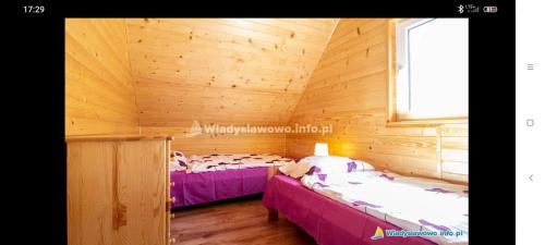 Zimmer mit 2 Betten in einer Holzhütte in der Unterkunft Domki SAMI in Władysławowo