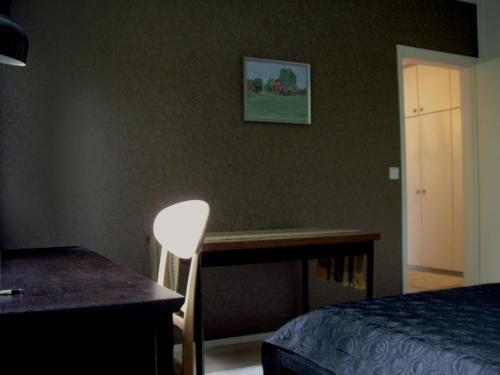 a bedroom with a desk and a bed and a chair at 21 minutes from Helsinki city - smaller room in Kauniainen