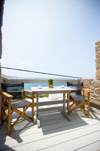 a table and chairs on a balcony with the ocean at Magic View Suites Mykonos in Mýkonos City