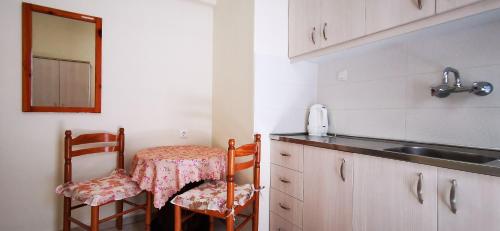 cocina con fregadero, mesa y sillas en All Summer Villa Dafni, en Olympiakí Aktí