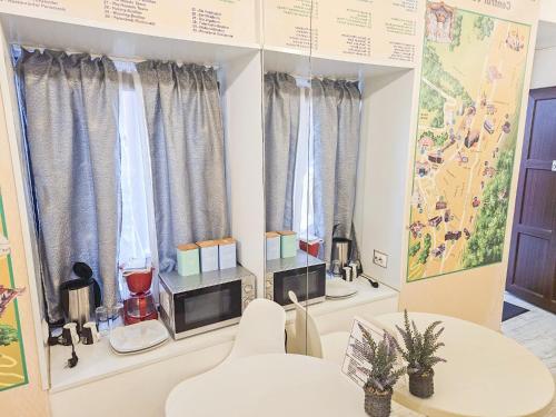 ein Raum mit Tisch und Stühlen und Fenstern in der Unterkunft StudioBoutique in Braşov