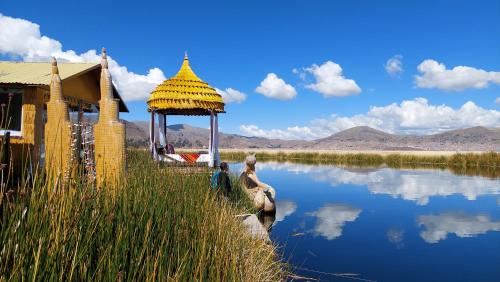a building with a gazebo next to a river at Uros Lodge Perú in Puno