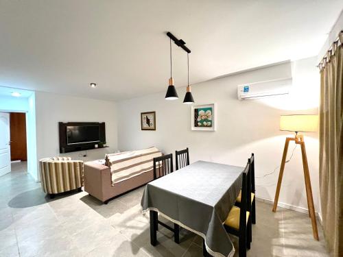 sala de estar con mesa y sofá en Lumiere Apartments - Elegante Departamento en Complejo Residencial en Mendoza