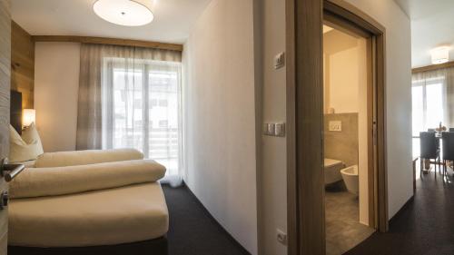 a room with two stools and a bathroom with a toilet at mittendorf klimaresidence in Schenna