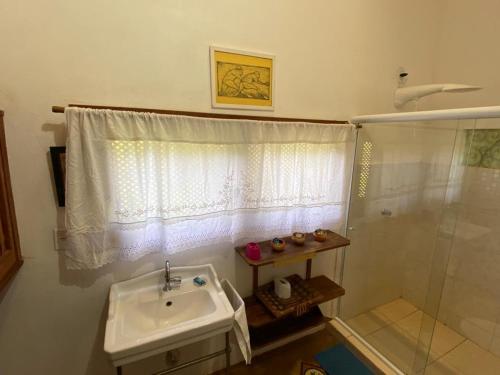 a bathroom with a sink and a shower at Casa nos Algodoes in Marau