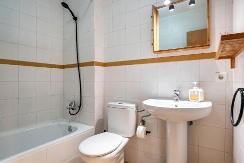 a bathroom with a toilet and a sink and a bath tub at Casa Señores Cura - Solo Familias in Conil de la Frontera