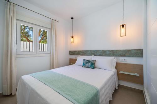 ein Schlafzimmer mit einem weißen Bett und einem Fenster in der Unterkunft Casita Piscina Cubierta Climatizada in Chiclana de la Frontera