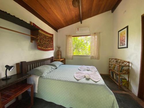Un dormitorio con una cama con un arco rosa. en Casa nos Algodoes, en Maraú
