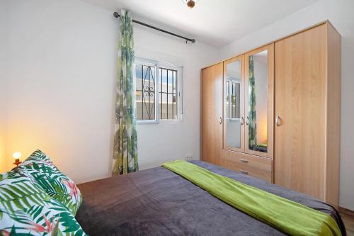 um quarto com uma cama e um armário de madeira em Casa Manoli 3 Chiclana em Chiclana de la Frontera