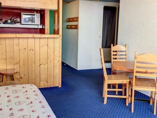 une pièce avec une table et des chaises et une cuisine dans l'établissement Appartement Ski aux Pieds · Balcon Sud/Ouest · Wifi Gratuit · Arc 1800 - FR-1-346-479, à Arc 1800