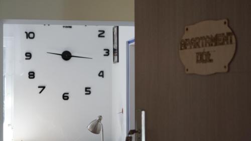 a clock on a wall next to a door at Domek nad jeziorem Drężno noclegi wynajem+sauna 