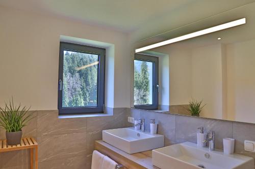 a bathroom with two sinks and two windows at Landhaus Barbara in Kitzbühel