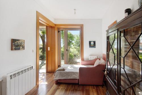 a bedroom with a bed and a living room at Villa do Bosque in Guilhabreu