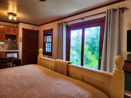 a bedroom with a bed and a large window at Oak Hill Inn in Julian