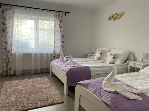 um quarto com duas camas com cisnes em Kincső Vendégház em Sárospatak