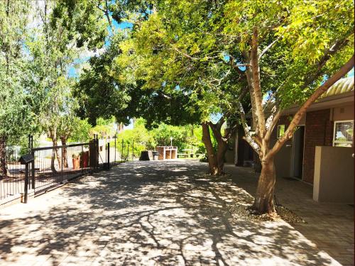 a walkway with trees on the side of a building at Tramonto Lodge in Upington
