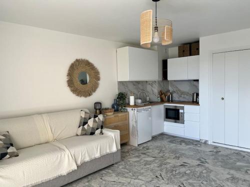 uma sala de estar com um sofá e uma cozinha em Studio cosy avec terrasse sur la plage em La Seyne-sur-Mer