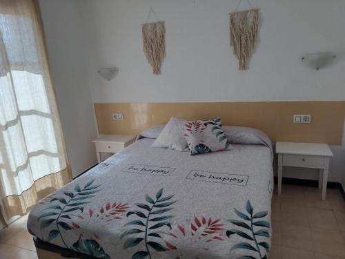 - une chambre avec un lit et une couverture dans l'établissement Apartamento con piscina y terraza en Ciutadella, Cala en Blanes, à Cala en Blanes