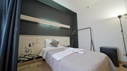 a bedroom with a white bed with a black wall at Hotel Nuovo Sole HNS in Bovolone